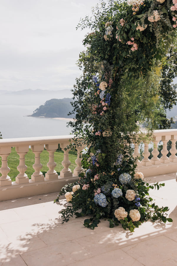 Arco floral para boda con vistas al mar en entorno elegante